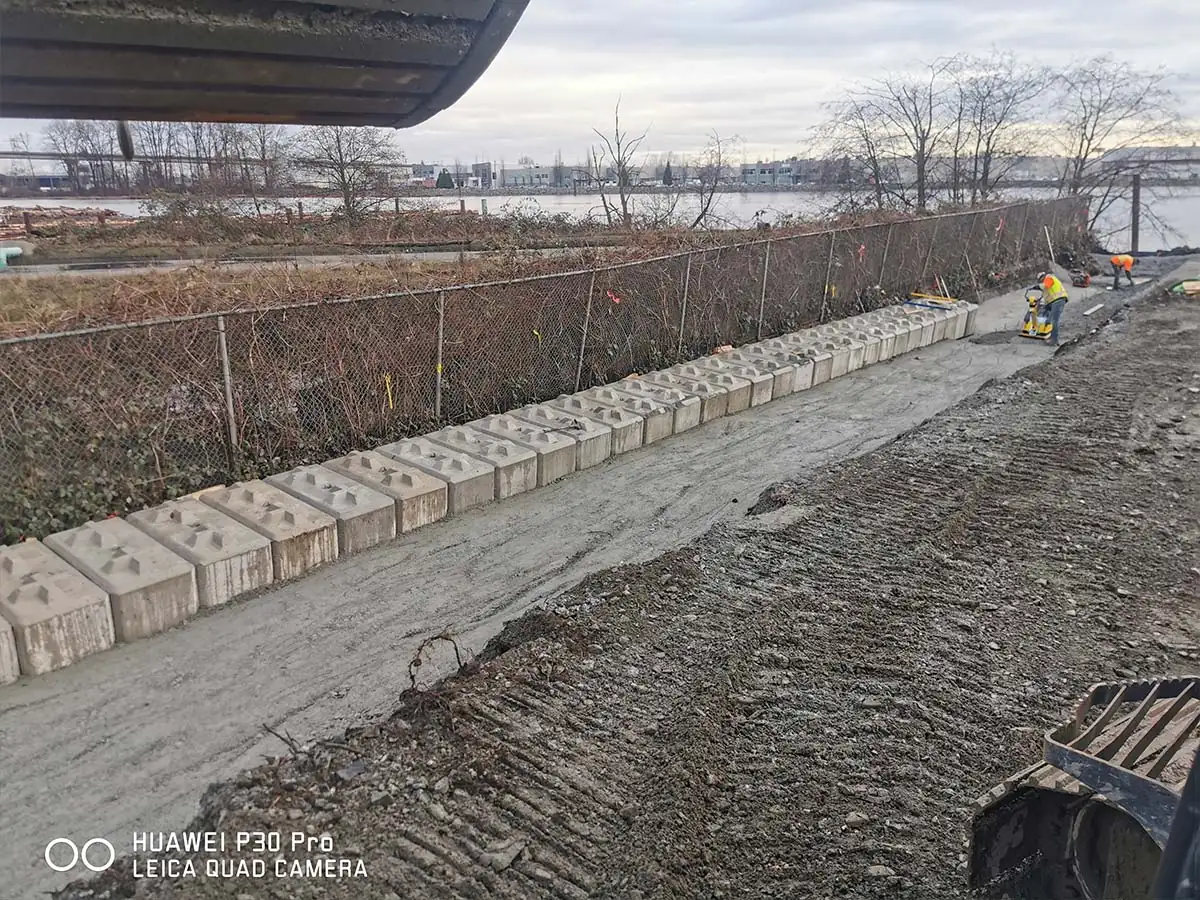Row of large concrete blocks along a waterfront yard