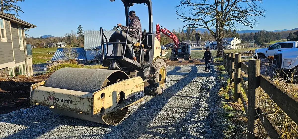 Roller compacting the new gravel driveway