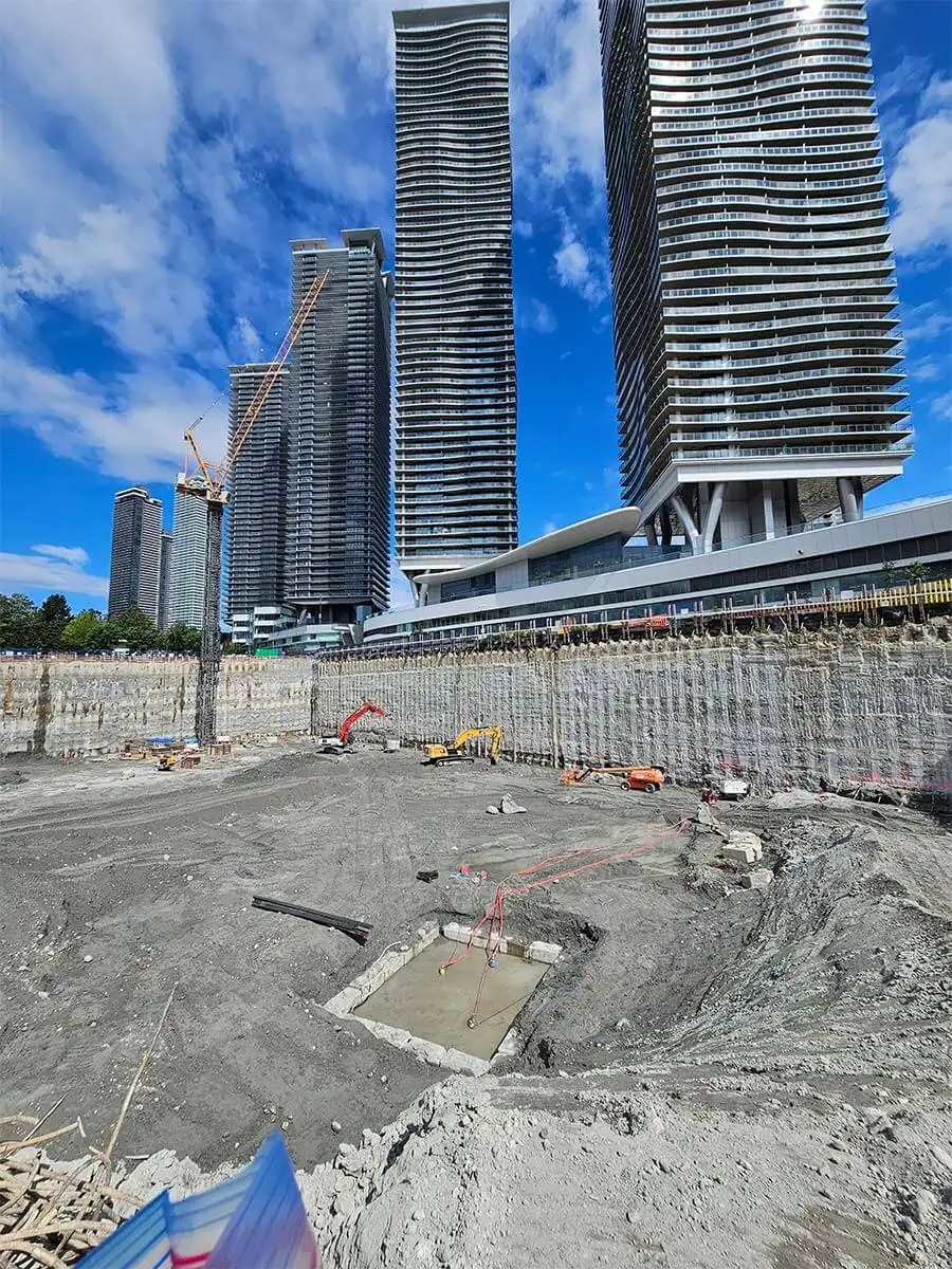 Deep excavation with high-rise towers rising behind the shored walls