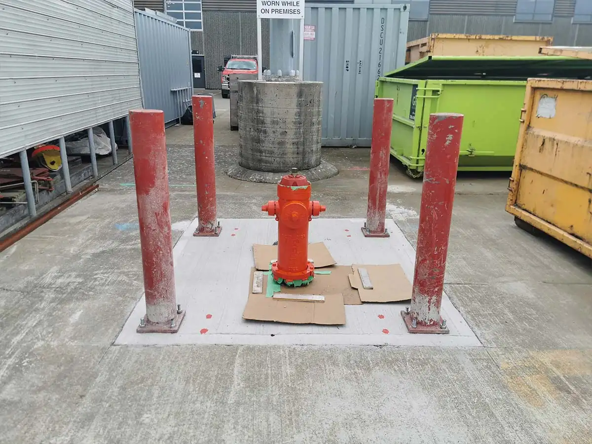 Hydrant pad with protective bollards