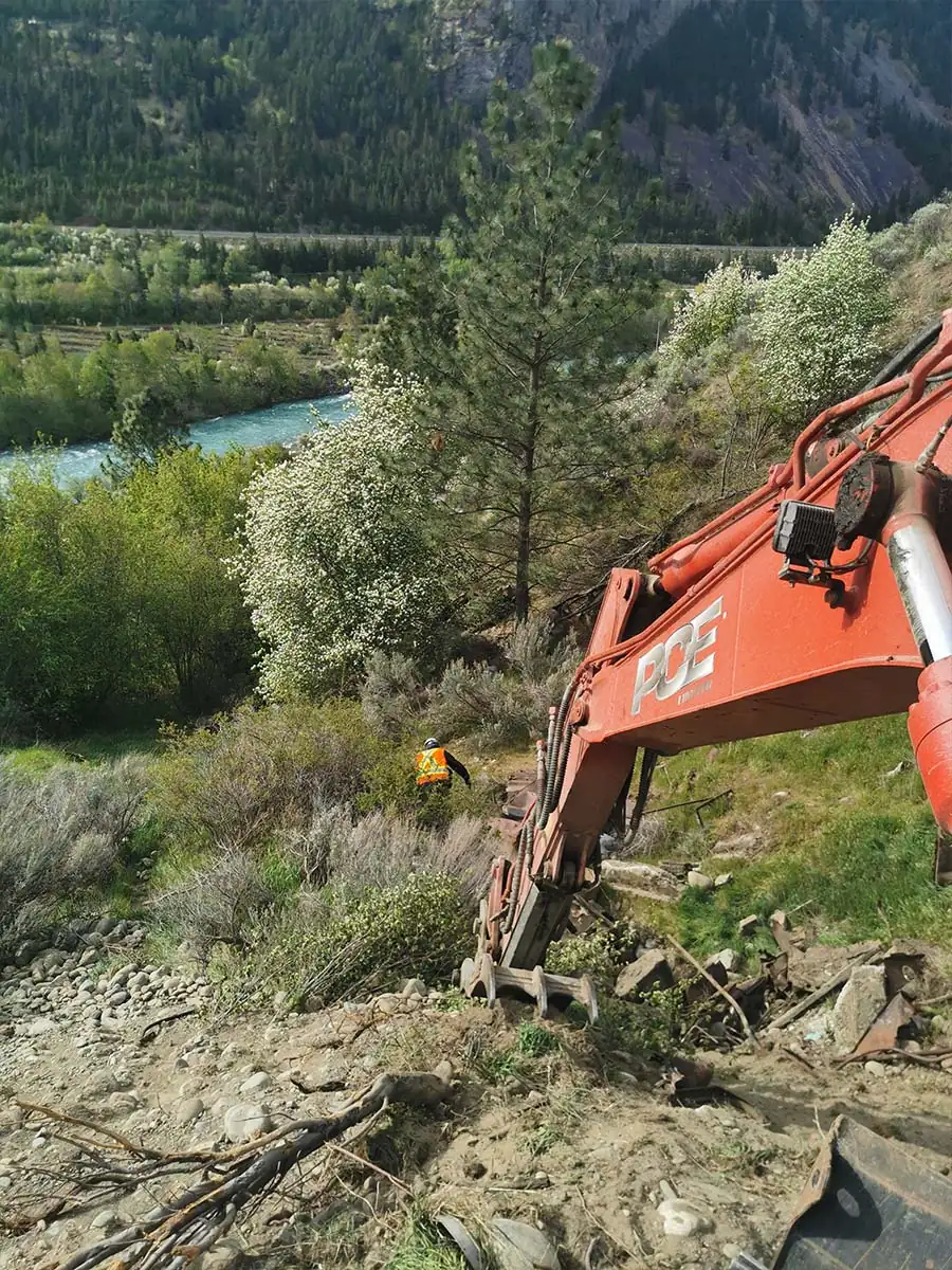 Excavator on a steep slope above the river