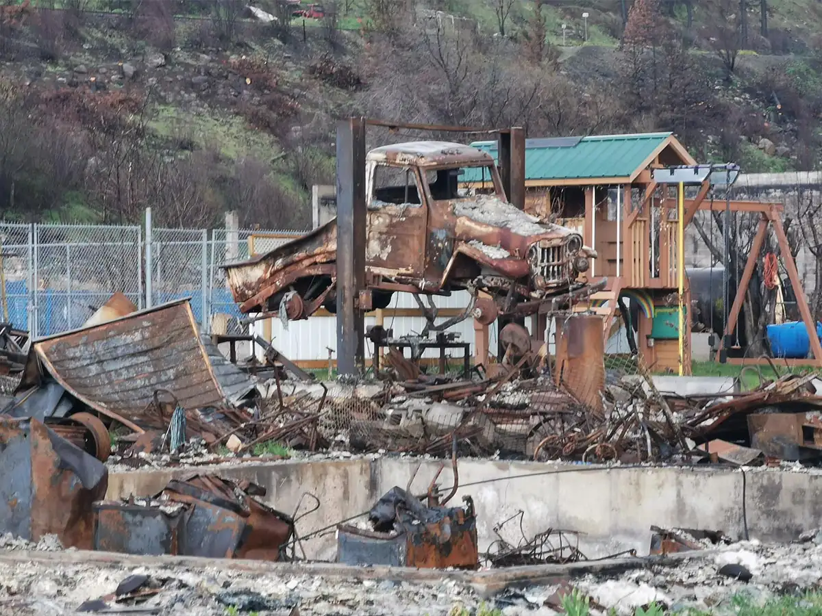 Burned vehicle and debris on a residential lot