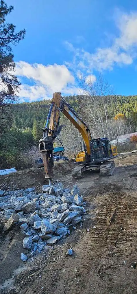 Excavator placing riprap along the bank