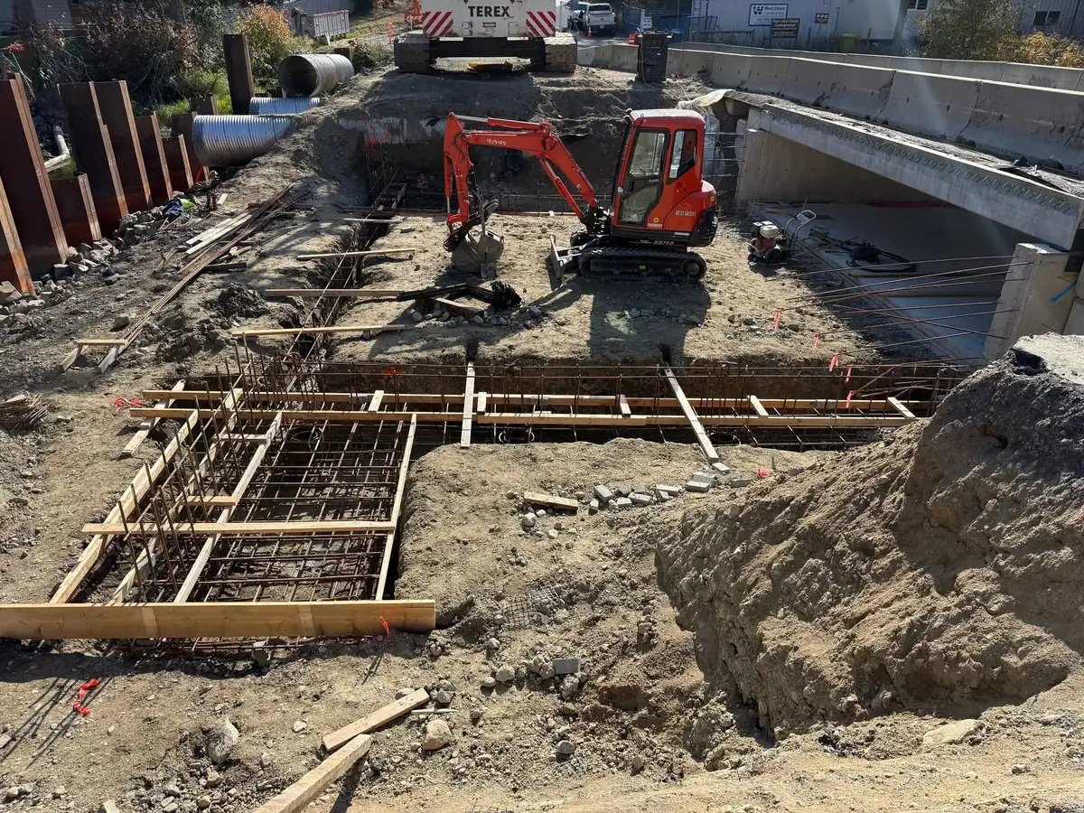 Compact excavator working between rebar mats and formwork