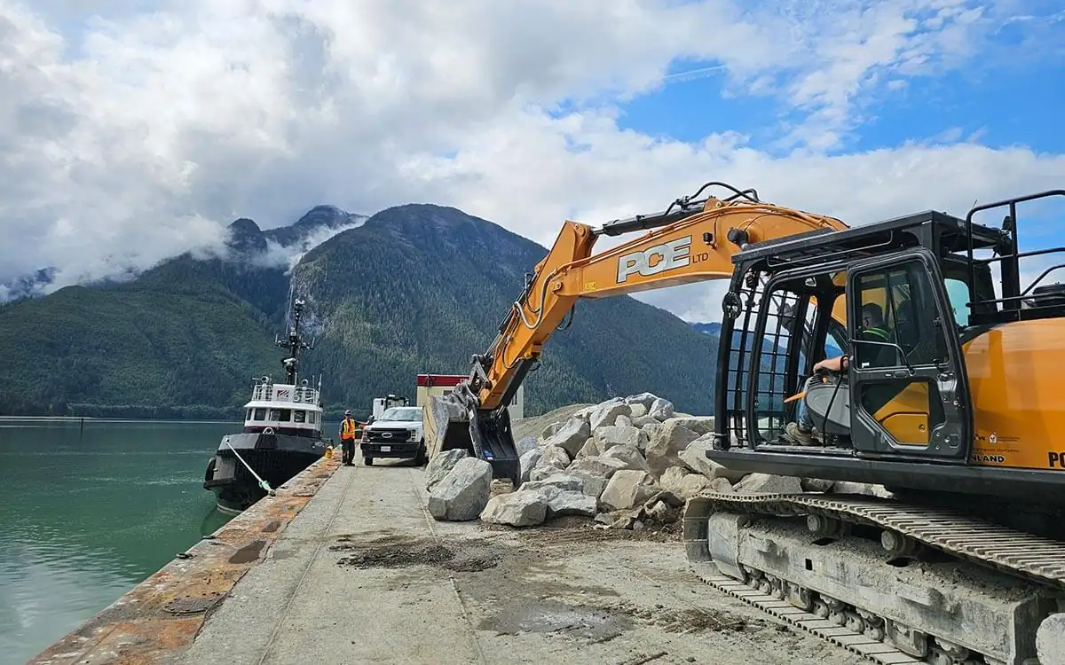 PCE Case excavator on the barge with a tug alongside