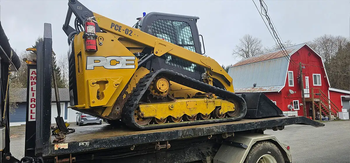 PCE compact track loader on a deck truck