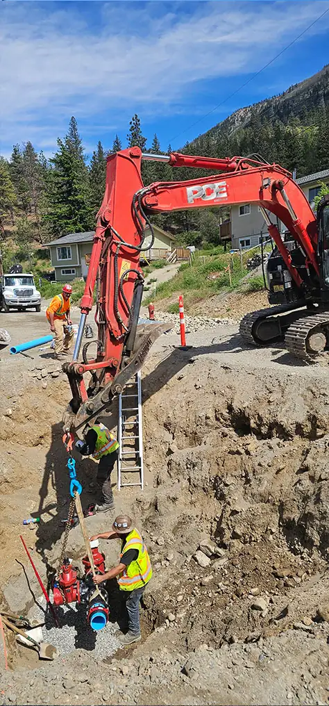 Excavator beside a deep water main repair excavation